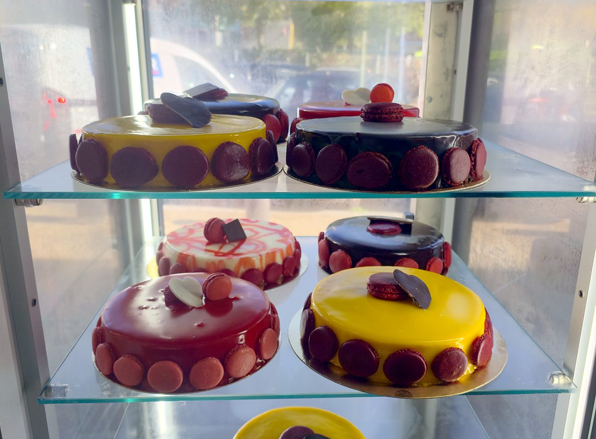 Entremets glacés rouges, jaunes et chocolat en vitrine, Le Mistral